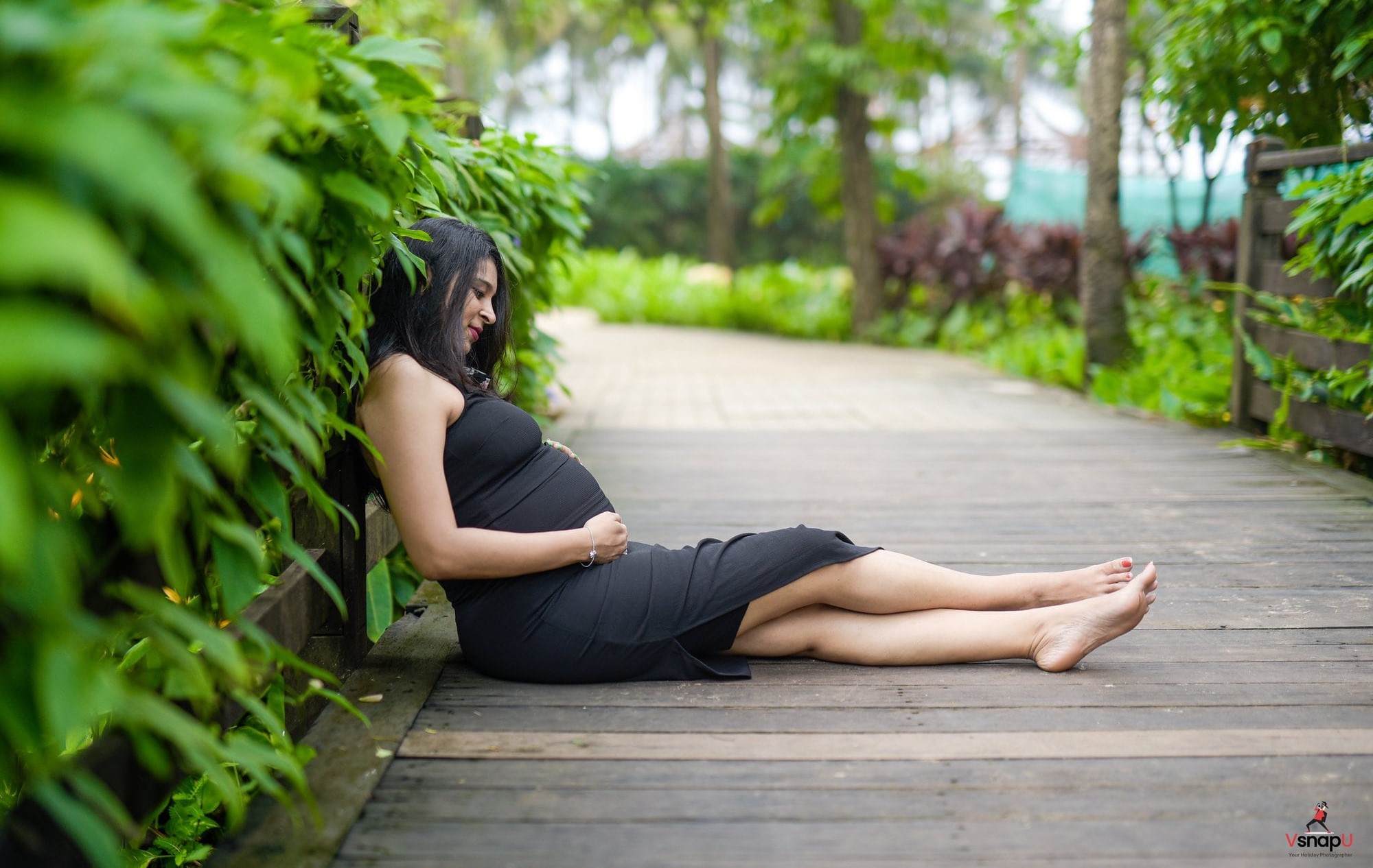 Garden maternity session with soft pose in black dress, Aligarh